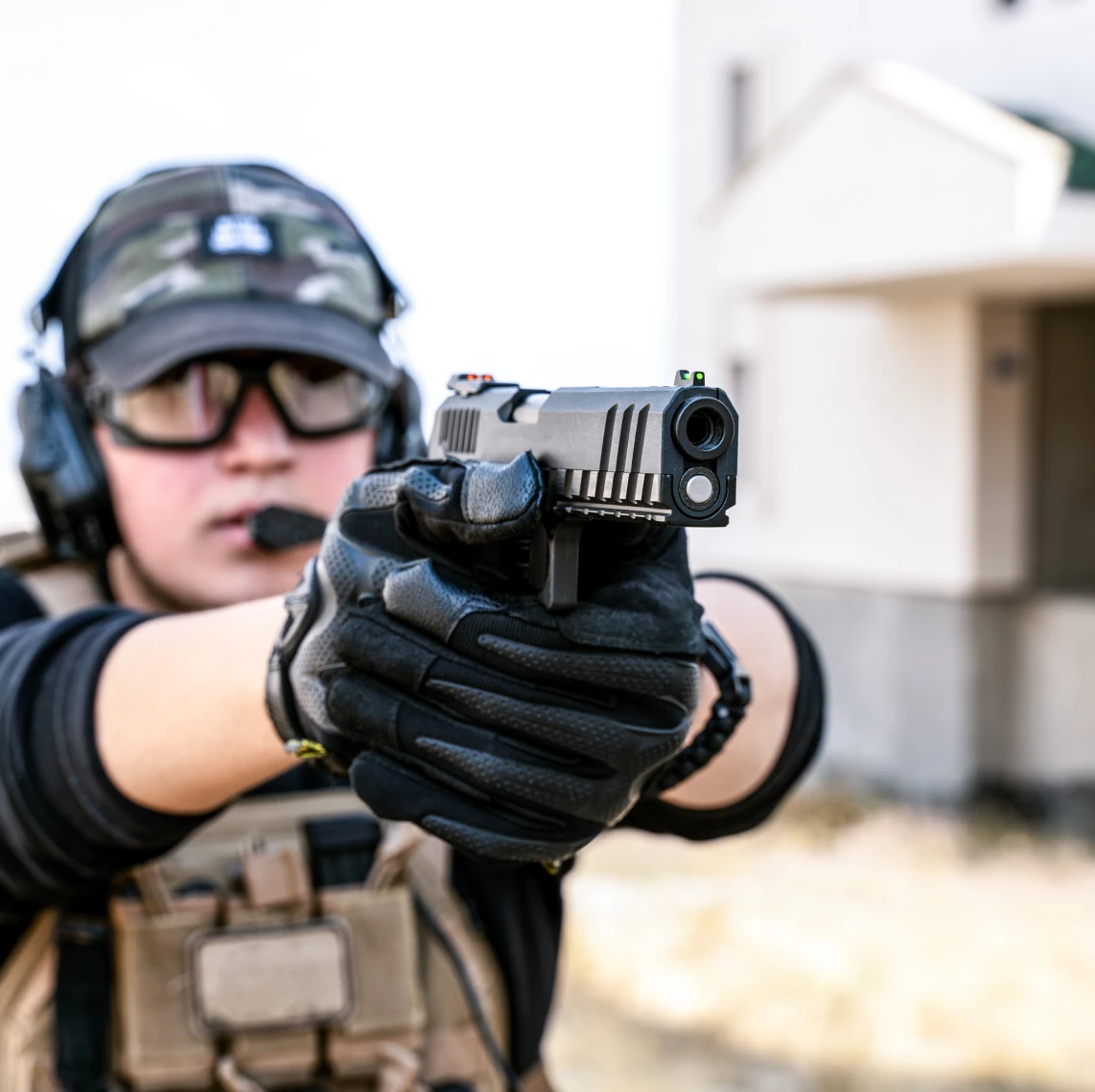 Person in gloves aiming a gun
